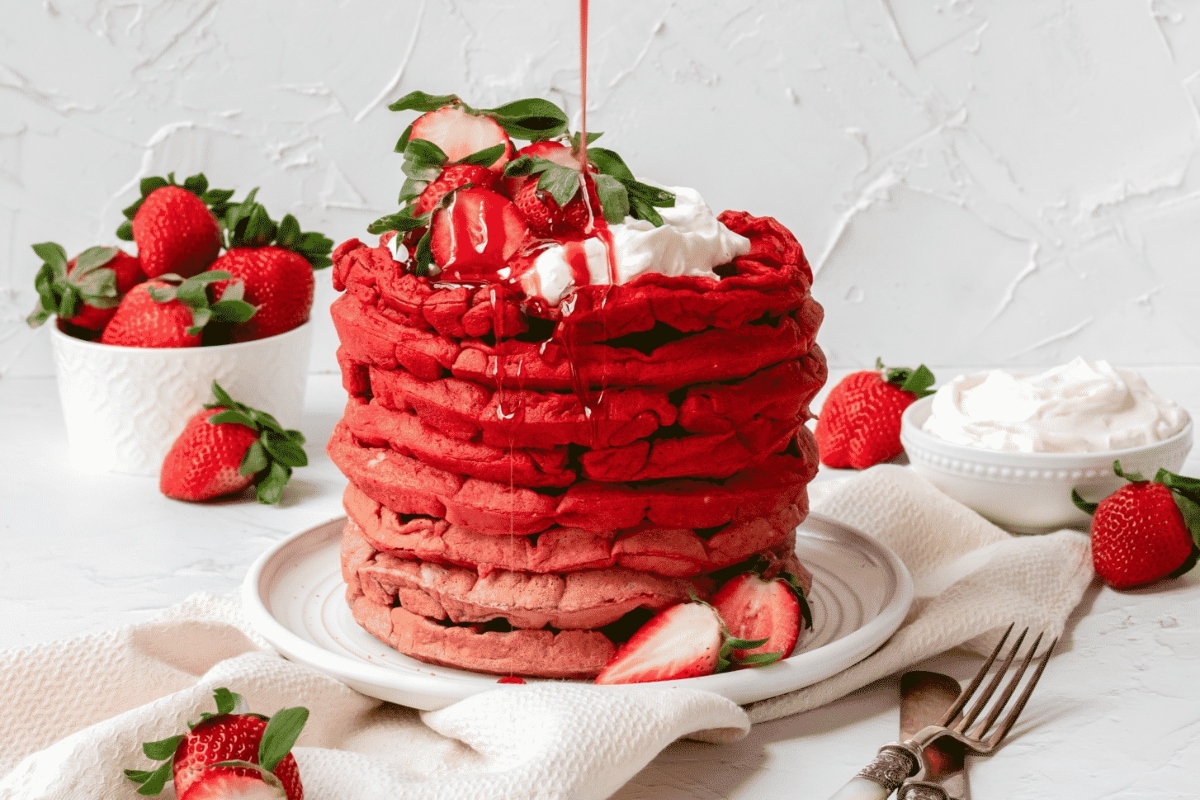 A stack of strawberry pancakes with whipped cream and strawberries recipe.