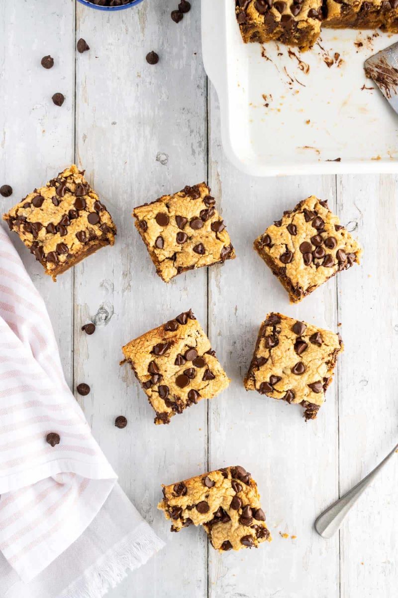 Peanut butter chocolate chip cookie bars on a wooden table.