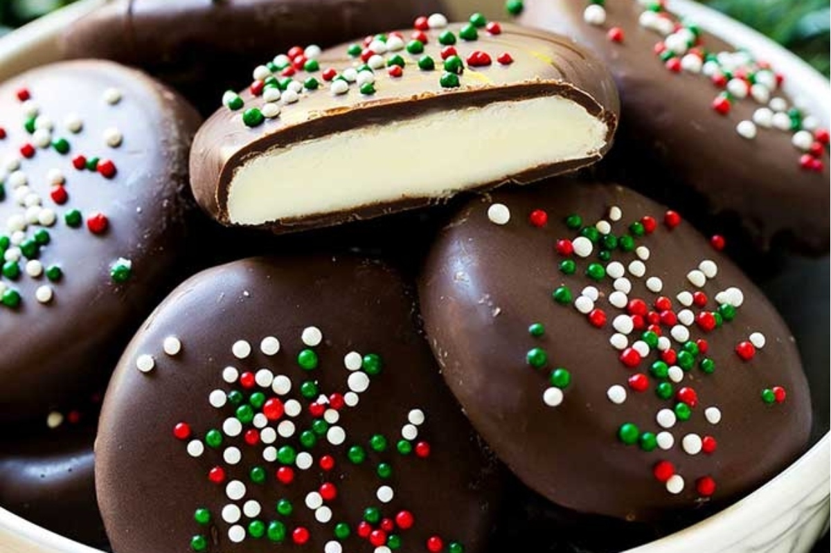 A bowl of chocolate covered cookies with sprinkles that are perfect for Christmas.