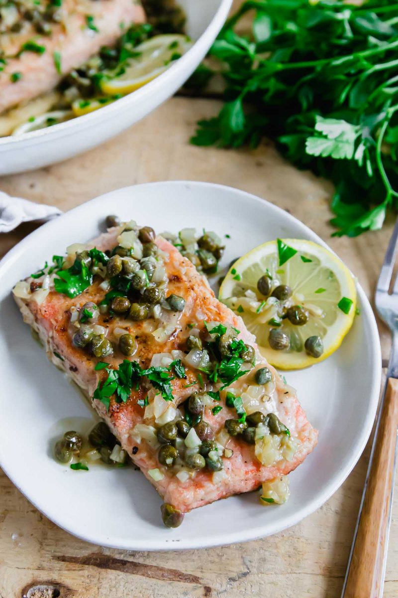 Salmon piccata with lemon and capers on a plate.