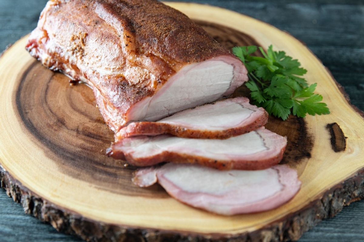 Sliced pork for winter dinners on a wooden cutting board.