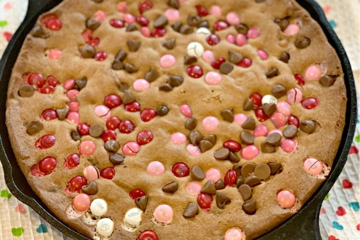 A decadent Valentines' Day dessert, a skillet filled with a chocolate cookie with sprinkles.