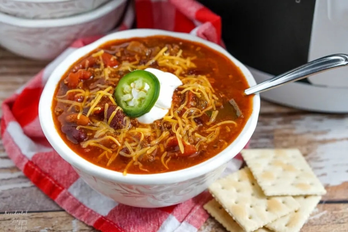 Slow Cooker Chili with crackers served in a white bowl.