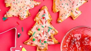 Shared roundup: Christmas cookies with icing and jam on a pink background.
