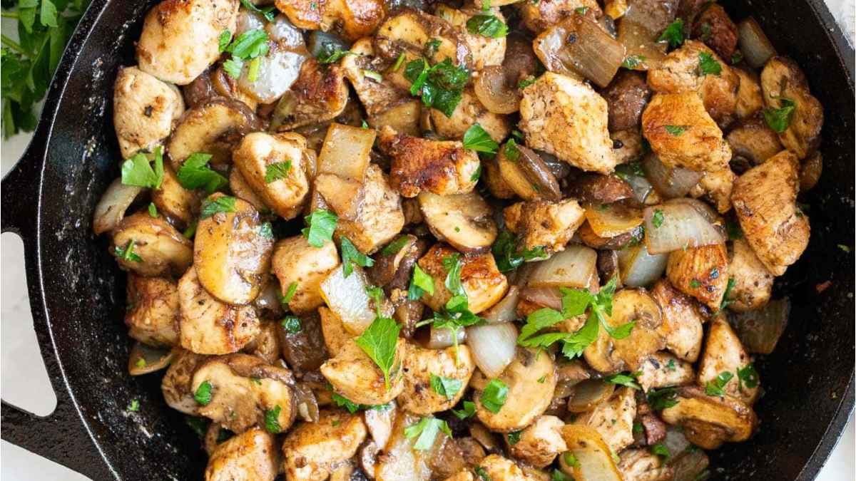 Chicken and mushrooms in a pan.