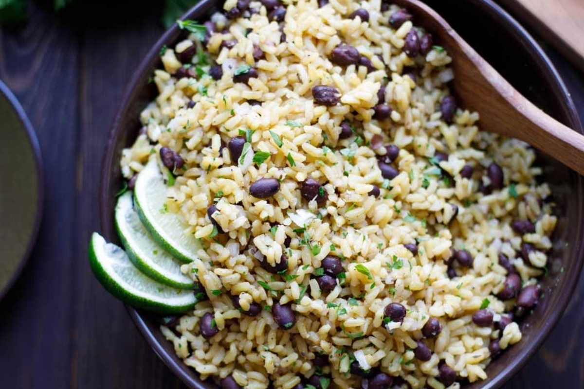 A bowl of mexican rice with black beans and lime.