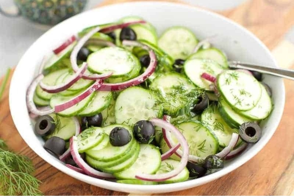 A bowl of cucumber salad with olives and onions, perfect for olive lovers.