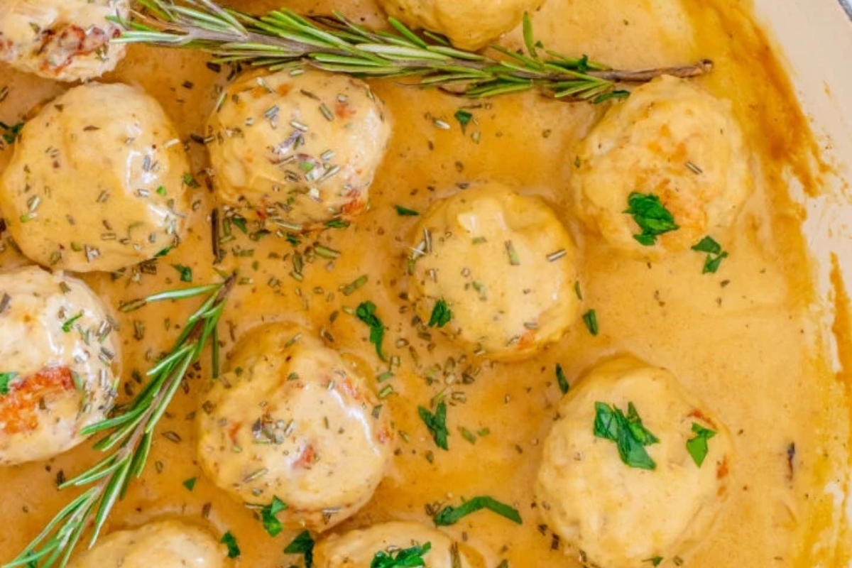 Swedish meatballs in a sauce with rosemary sprigs.