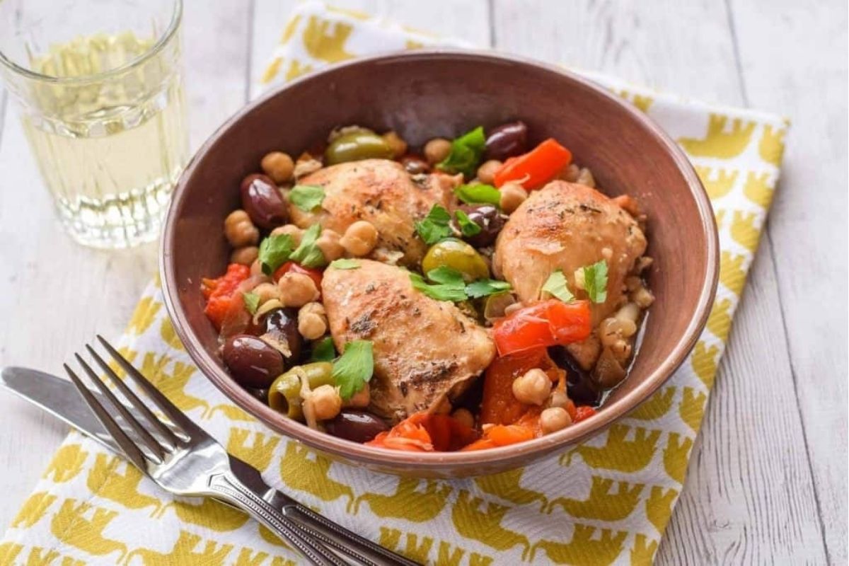 Slow cooker chicken with olives in a brown bowl.