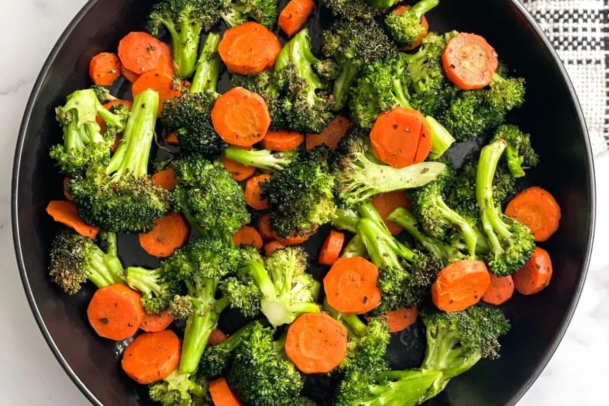 A pan with broccoli and carrots in it.