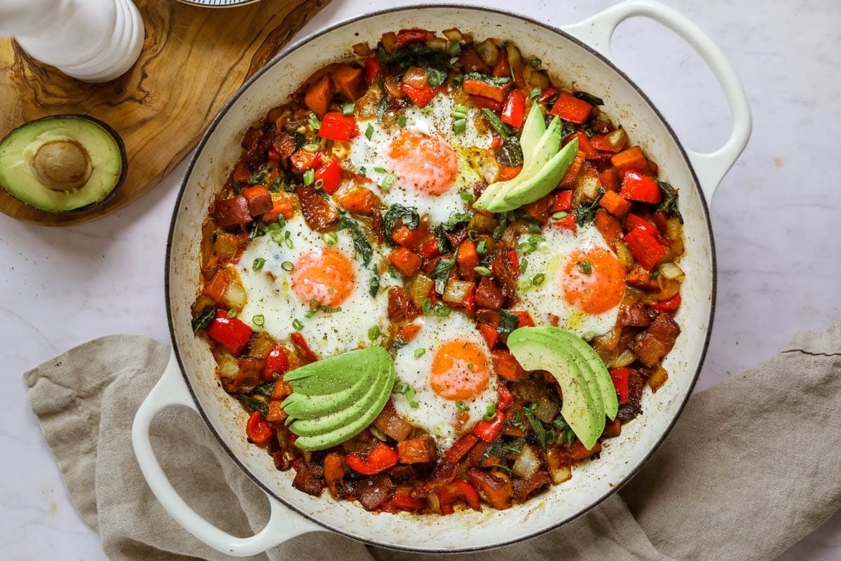 Creative Sweet Potato Recipes 18 A skillet filled with eggs, avocado, and bacon.