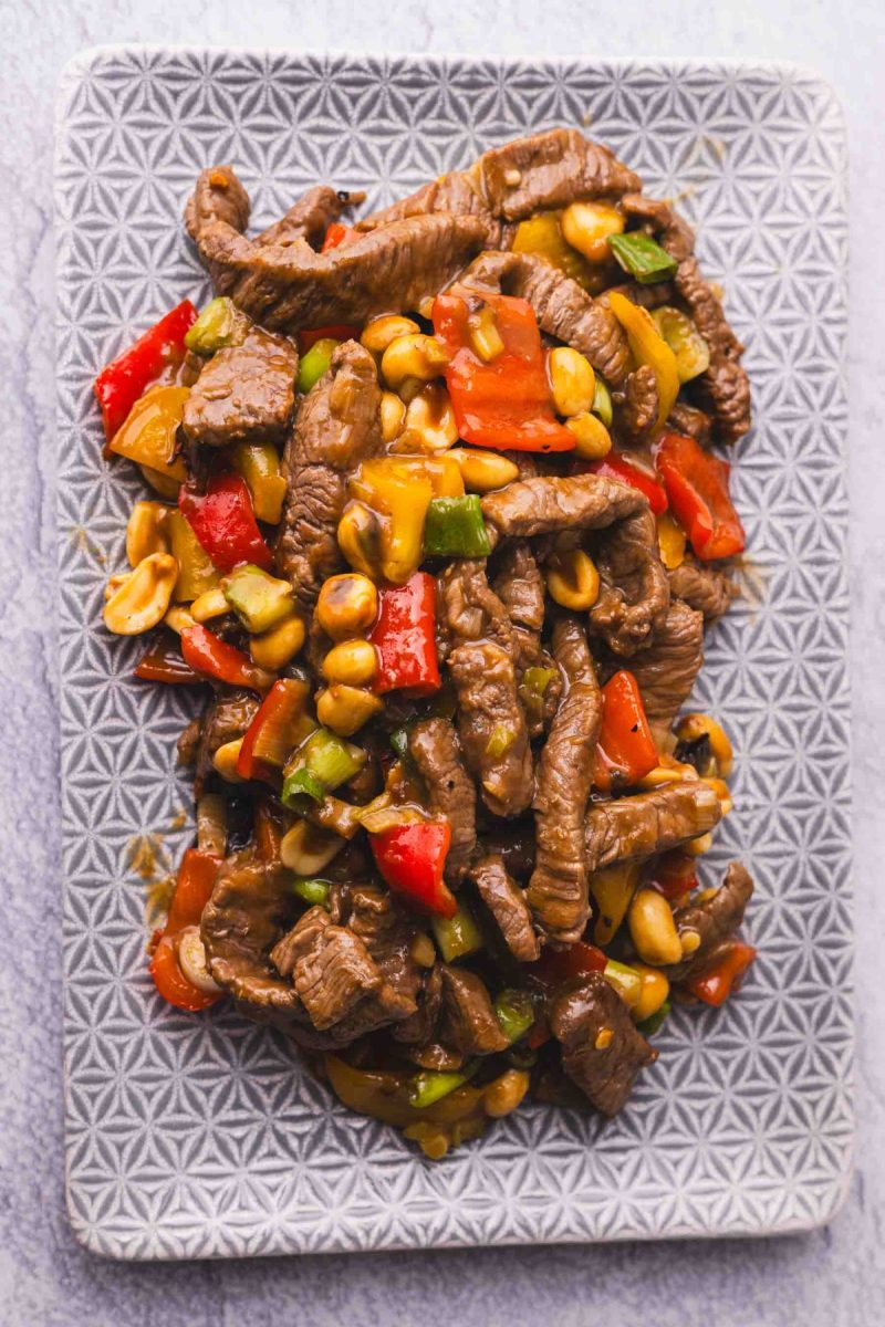 Kung pao beef stir fry with peppers and peanuts on a plate.
