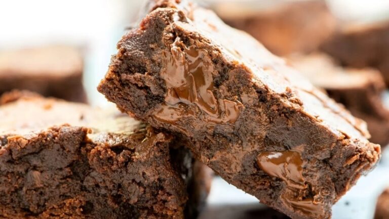 A stack of brownies with caramel on top.