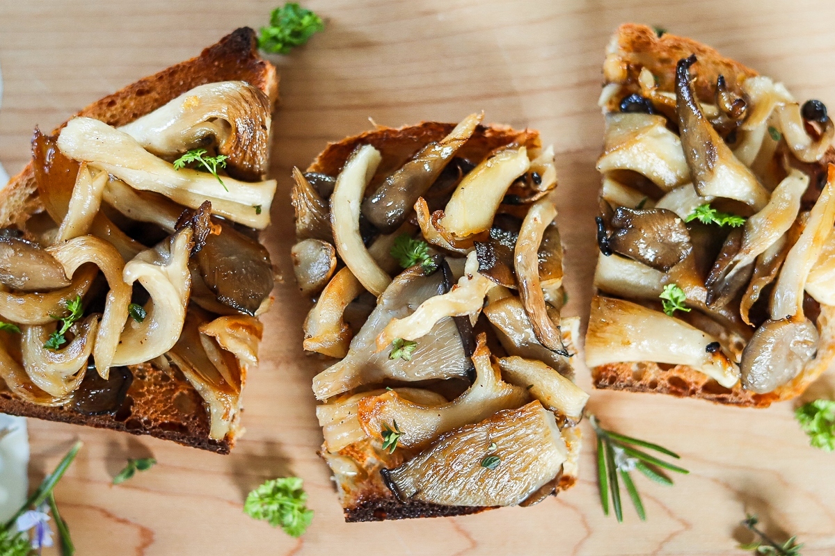 A slice of bread with mushrooms and herbs on it.