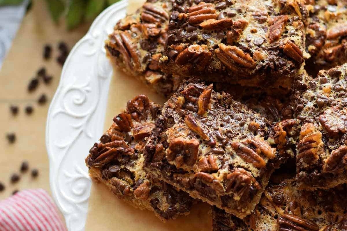A stack of chocolate pecan bars on a plate.