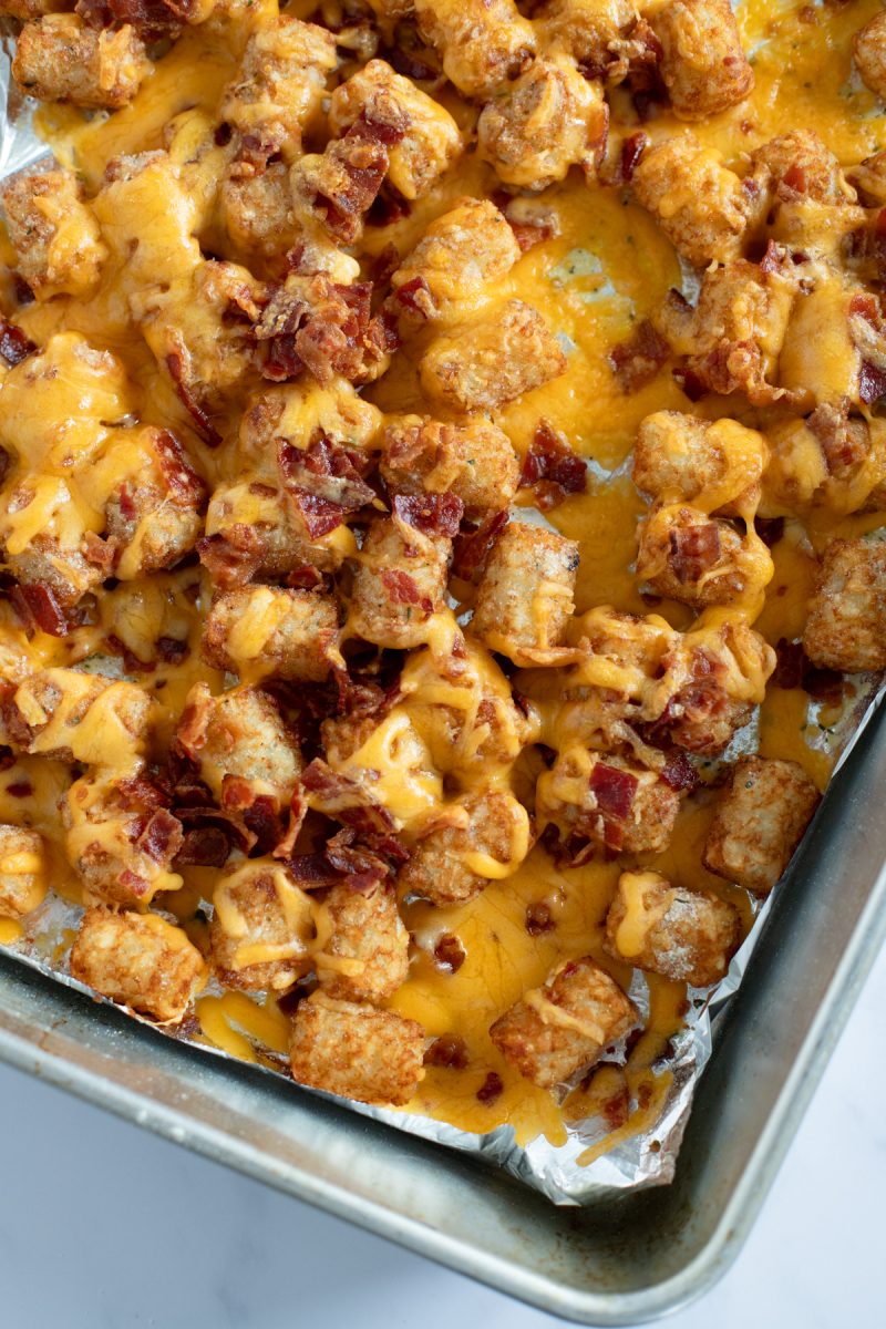 A tray of loaded tater tots with cheese, and bacon.