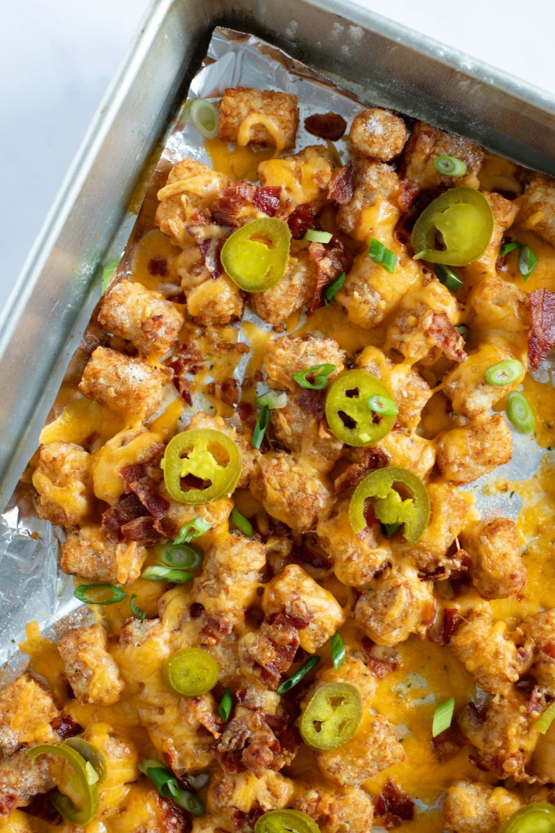 A tray of loaded tater tots with cheese, bacon and jalapenos.