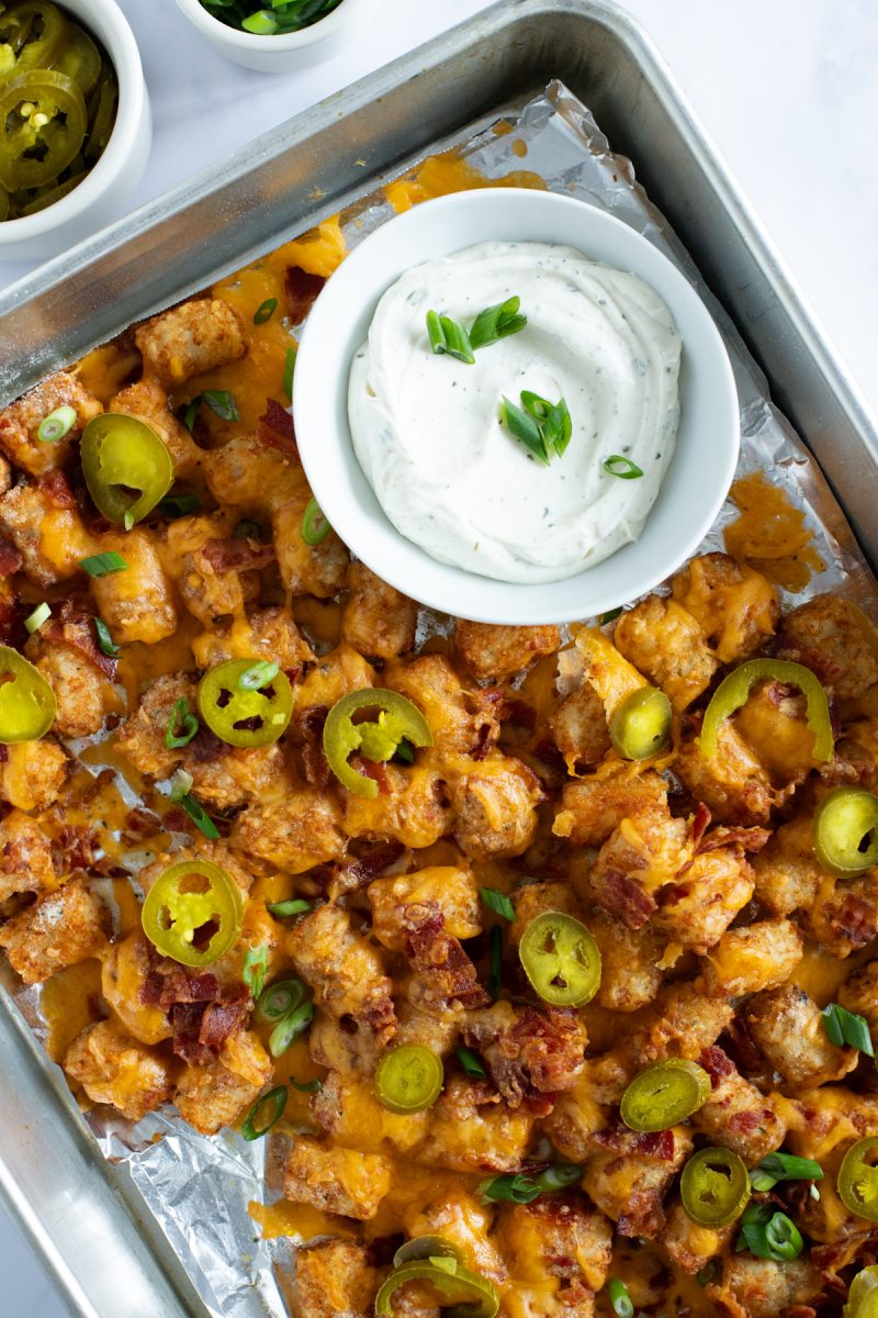 A tray of loaded tater tots with cheese, bacon and jalapenos.