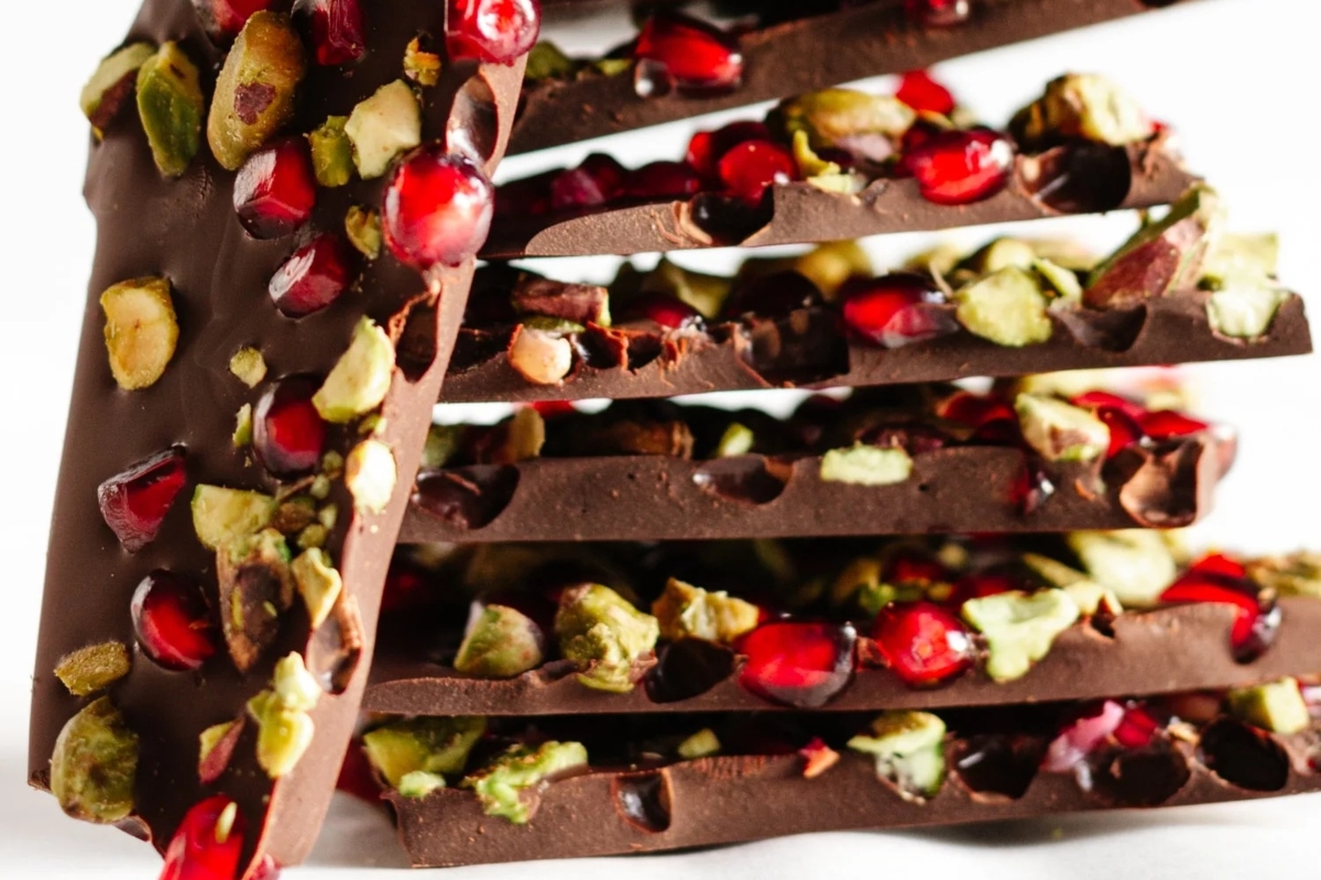 A stack of chocolate bars with pomegranate and pistachios.