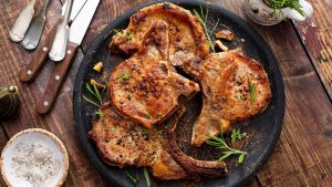 Grilled or pan fried pork chops on the bone with garlic and rosemary.