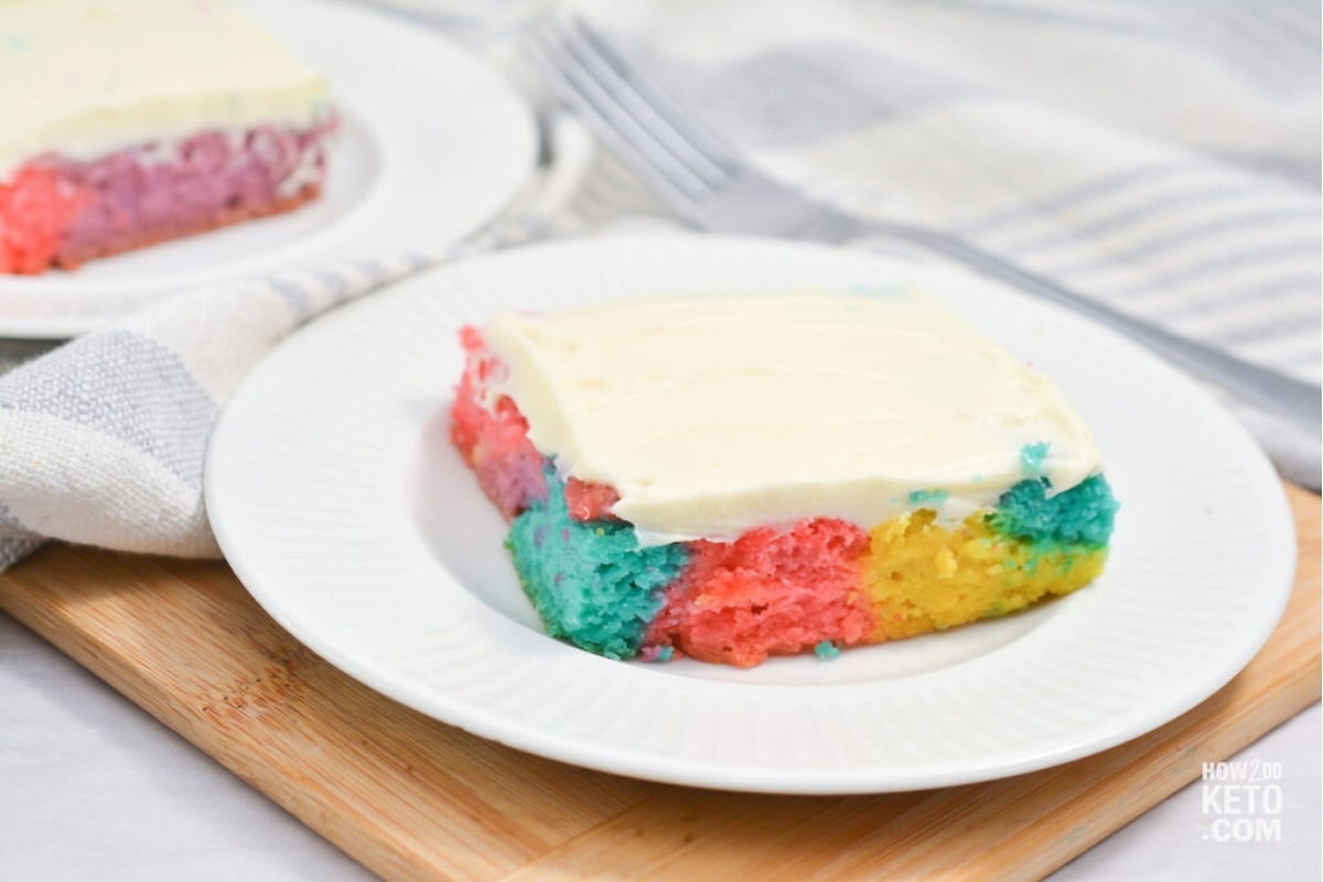 Rainbow cake on a plate with a fork.