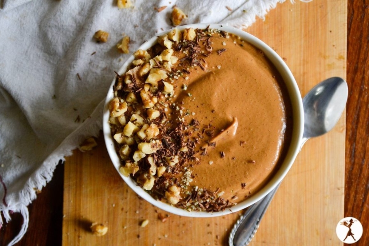 Creative Sweet Potato Recipes 22 A chocolate and sweet potato smoothie bowl with nuts on a cutting board.