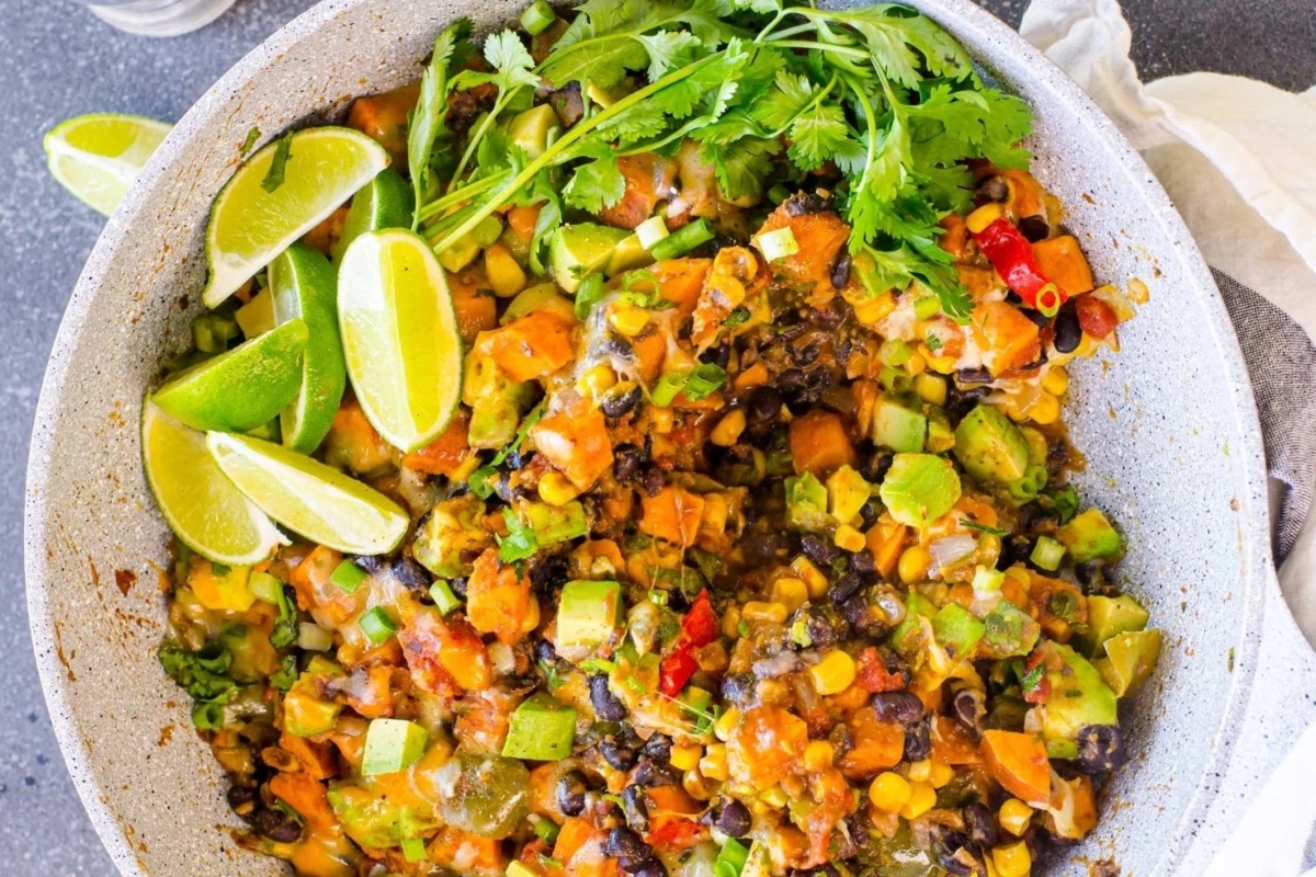 Creative Sweet Potato Recipes 12 A bowl of black beans and sweet potatoes with lime wedges.