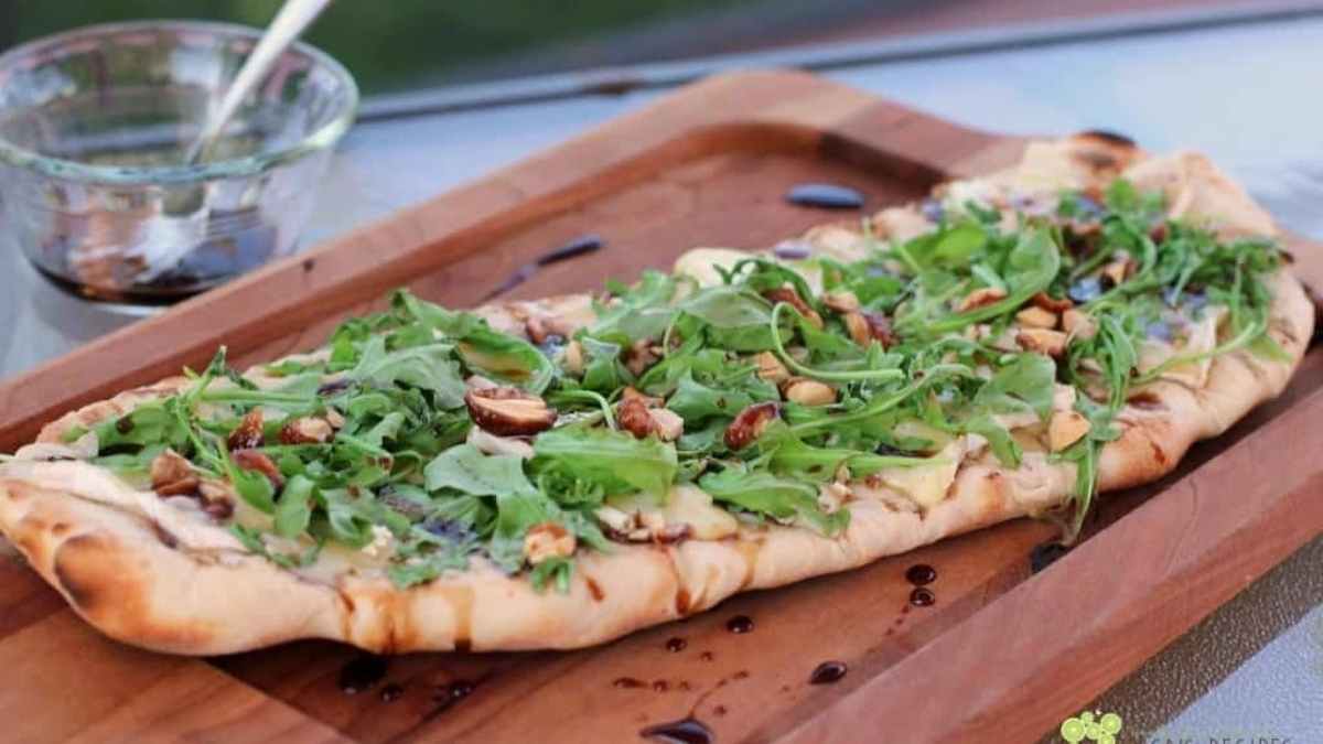 Grilled Flatbread with Brie, Arugula, Candied Nuts, and Balsamic-Honey Drizzle.