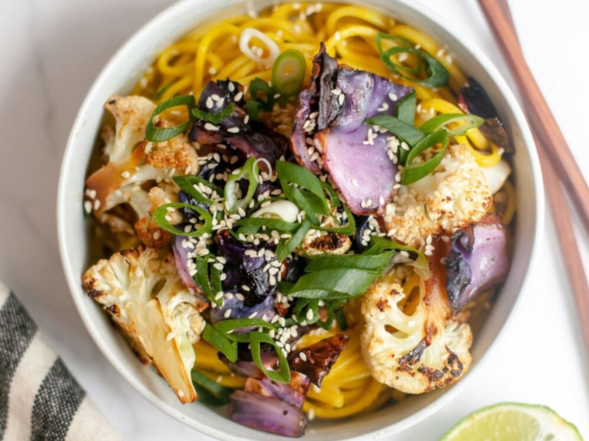 Bowl of udon noodles with cabbage and cauliflower.