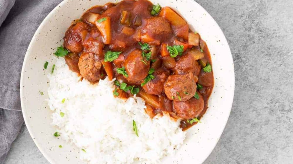 Vegan meatballs on a white plate with white rice.