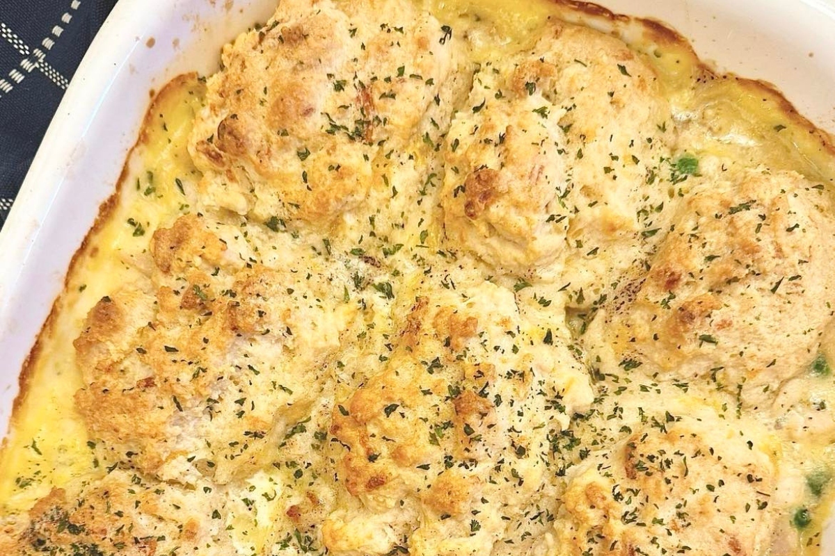 A freshly baked casserole with a golden-brown crust, sprinkled with herbs.