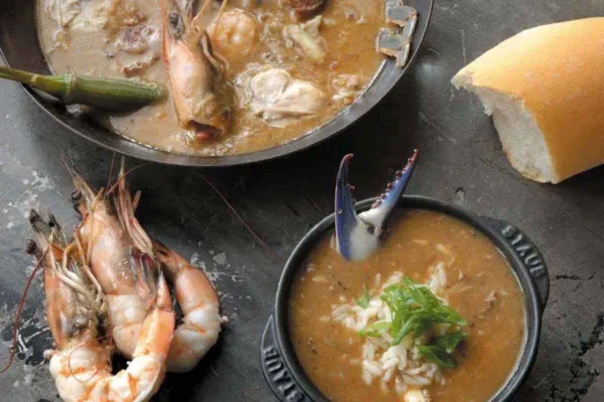 A group of bowls of soup and shrimp.