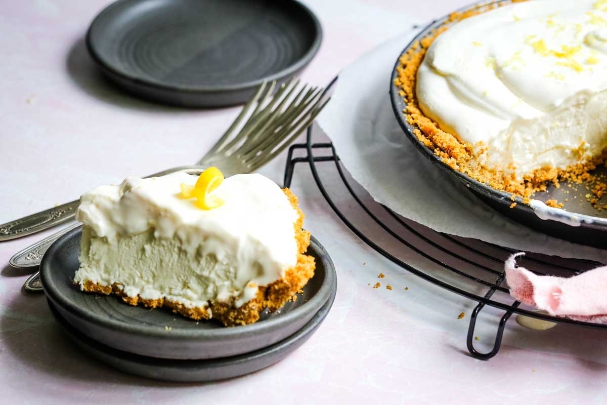 A slice of lemon pie on a plate with a fork.