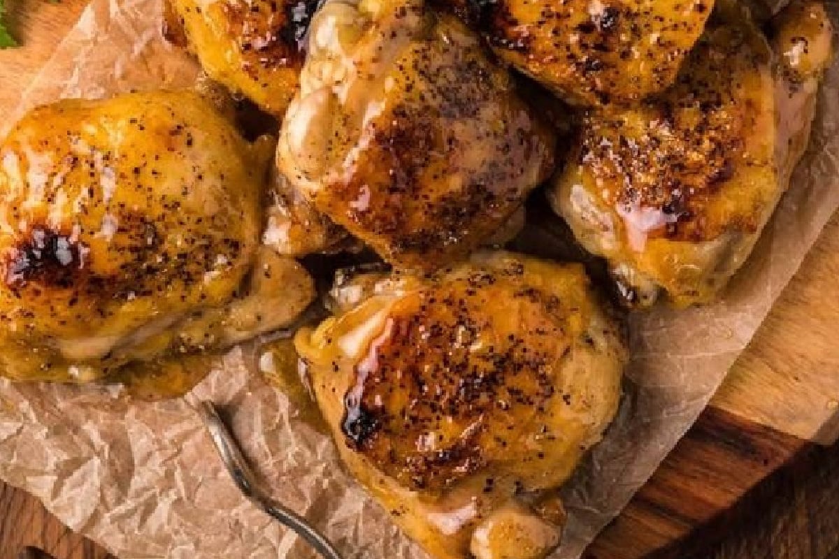 23 Finger-Lickin' Good Chicken Thigh Recipes That Are Simply Irresistible 4 Several pieces of glazed, roasted chicken thighs on a piece of parchment paper with a small fork beside them, perfect for easy chicken thigh recipes.