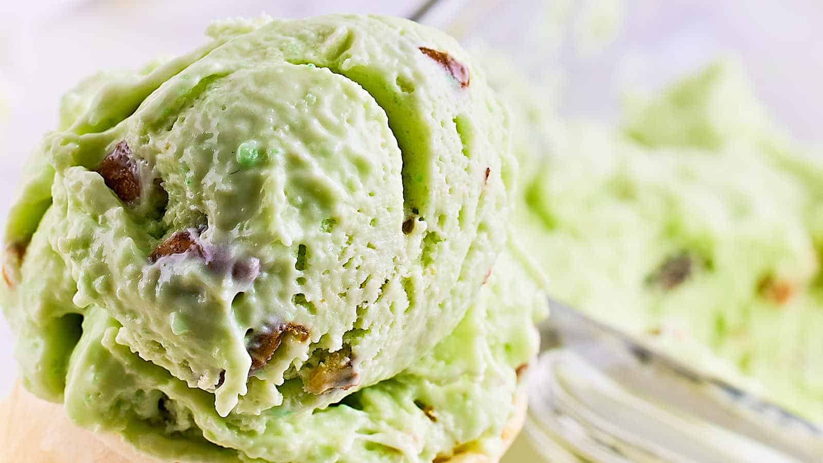 An ice cream cone filled with green ice cream.